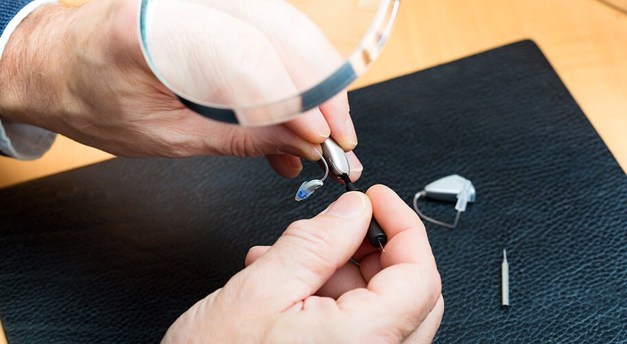 specialist performing hearing aid repairs